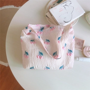 Détail du sac à épaule en toile rose matelassée avec motif de cerises mignon