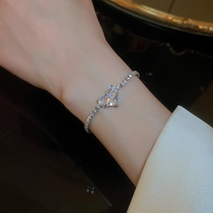 Detail of silver double heart bracelet with cubic zirconia on female wrist