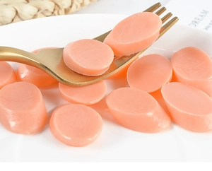 Close-up of pink-orange oval waxing beans for professional hair removal treatment