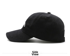 Side view of black cotton baseball cap with white embroidery detail and curved brim