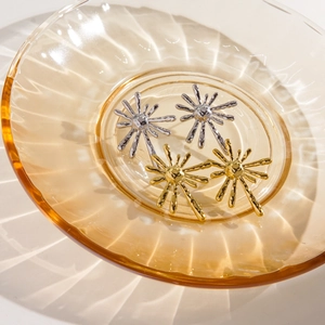 Starburst sunburst 14K gold and silver stainless steel stud earrings in glass bowl