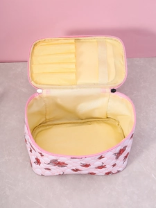 Macro shot of pink makeup bag showing yellow interior lining and makeup brush slots