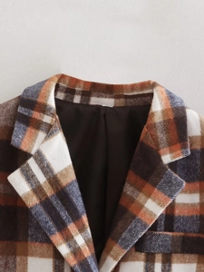 Detail of the notched lapel on a brown plaid wool blazer with clear fabric texture