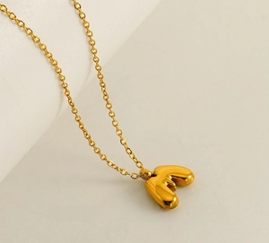Detailed view of bubble 18K gold letter F pendant necklace in polished stainless steel