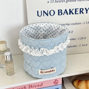 Close-up of heart quilted light blue fabric storage basket with delicate lace trim