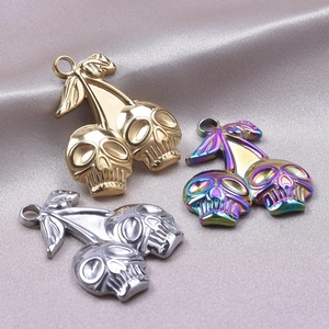 Macro detail of cherry skull pendants in gold, silver and rainbow on grey satin
