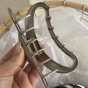 Close-up of matte silver crescent hair claw clip showing brushed metal texture and spring