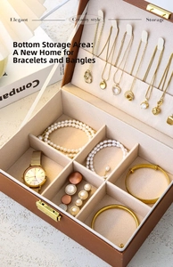 Brown leather jewelry box with multi-compartment storage and necklace hooks detail