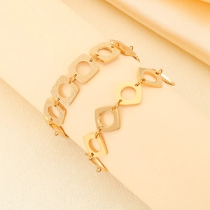 Détail du bracelet à maillons carrés évidés en acier inoxydable plaqué or 18 carats