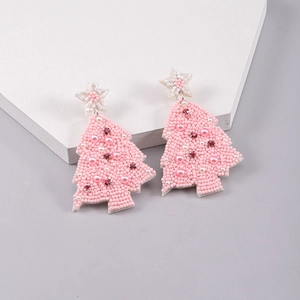 Detail of handmade pink beaded Christmas tree earrings with pearls and red rhinestones