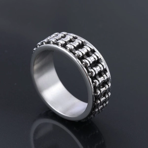 Macro detail of industrial mechanical link pattern on a wide stainless steel ring