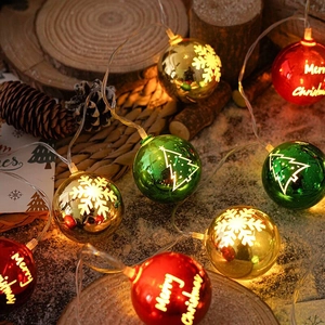 Detail of red green and gold Christmas LED ball string lights with Merry Christmas patterns