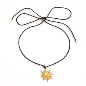 Dettaglio di una collana con ciondolo a sole dorato con cordino intrecciato nero regolabile