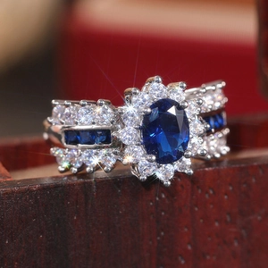 Makroaufnahme von Silberring mit ovalem blauem Edelstein und Zirkon-Blumenfassung