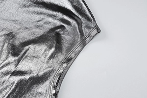 Detail of silver metallic fabric showing smooth stitching and shiny texture on the dress
