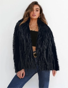 Detail shot of black faux fur short jacket with fluffy texture and long hair finish