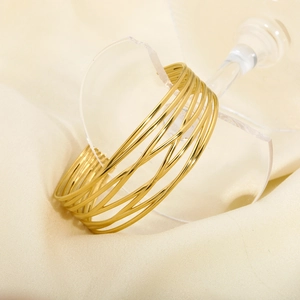 Detailed view of layered gold-tone wire wrap open bangle with a hollow cutout design