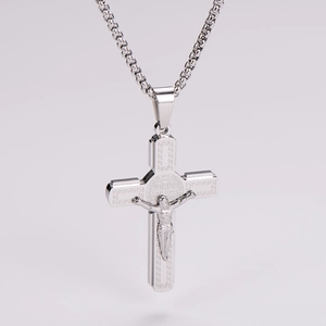Détail du collier crucifix argenté avec figurine de Jésus et motifs grecs