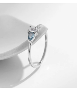 Close-up of a 925 sterling silver ring featuring a blue pear-cut stone and emerald-cut gem