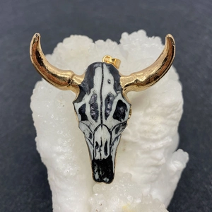 Detailed view of luxury bull head pendant with black white enamel and gold horns