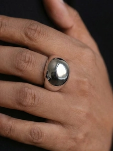 Detailed view of a silver polished dome ring on finger with modern minimalist style