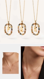 Detail of P, Q, and R gold necklaces featuring colorful crystal-encrusted letters