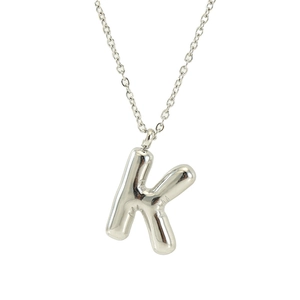 Polished silver stainless steel puffy letter K bubble pendant necklace on white background
