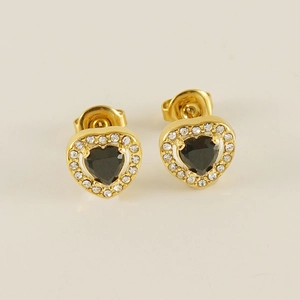 Gros plan de boucles d'oreilles cœur dorées avec pierre noire et bordure en zircon