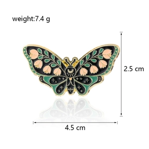 Detail of enamel butterfly brooch with pink floral patterns and gold metal edges