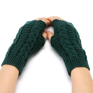 Detailed knit texture of dark green fingerless gloves showing cable stitch pattern