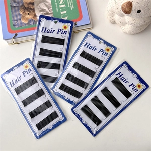 Macro detail of four packs of black bobby pins with ball tips on a clean white background