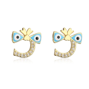 Detail of gold bow earrings featuring blue evil eye enamel and shimmering crystals