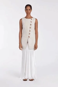 Detailed close-up of beige linen sleeveless top with asymmetric button closure and white skirt