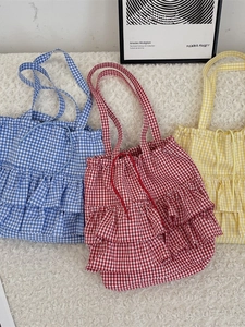 Plaid canvas tote bags with ruffle trim in blue red and yellow on soft wool background