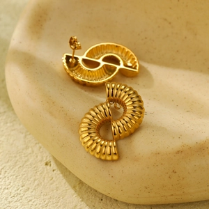 Moderne hohle gedrehte Goldohrringe aus Titanstahl mit spiralförmigem Design auf Keramik