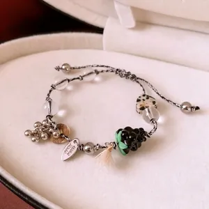 Handmade beaded bracelet with heart stones, tassels, and charms in a velvet jewelry box