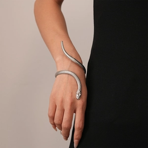 Detailed view of silver snake-shaped arm cuff with intricate scale engraving on a model