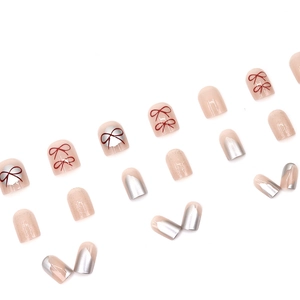 Short square peach pink press-on nails with red bow and silver french tip design