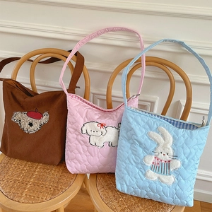 Detail of heart-quilted corduroy crossbody bags with cute animal embroidery art