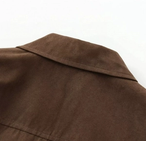 Detailed close-up of dark brown faux suede collar and stitching on a crop jacket