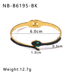 Detail of snake bangle with black scales, green gem eyes, and snap clasp closure