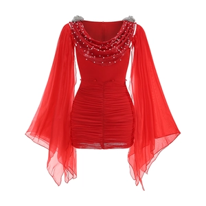 Détail d'une robe de soirée rouge avec décolleté en V à paillettes et manches mousseline