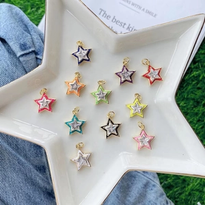 Colorful star-shaped enamel pendants with zircons in a white ceramic star-shaped tray