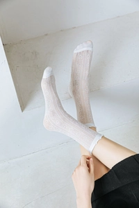 Close-up of white lace crew socks featuring vertical stripes and heart patterns