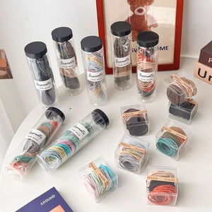 Close-up of assorted colorful elastic hair bands in clear cylindrical packaging