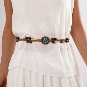 Detail of bohemian waist chain with brown wood beads and turquoise flower metal buckle