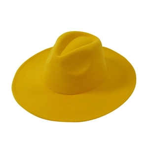 Detail of a bright yellow wide brim wool fedora hat with fine stitching and classic crown