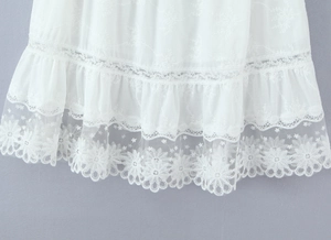 Détail de broderie en dentelle blanche et bords à volants sur ensemble jupe