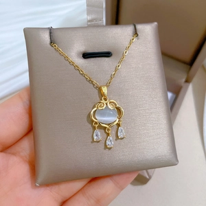 Close-up of gold titanium necklace featuring opal ruyi lock and teardrop zircons