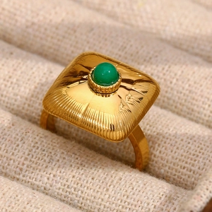 Detail shot of vintage 18K gold plated square ring with a green gemstone in a jewelry box